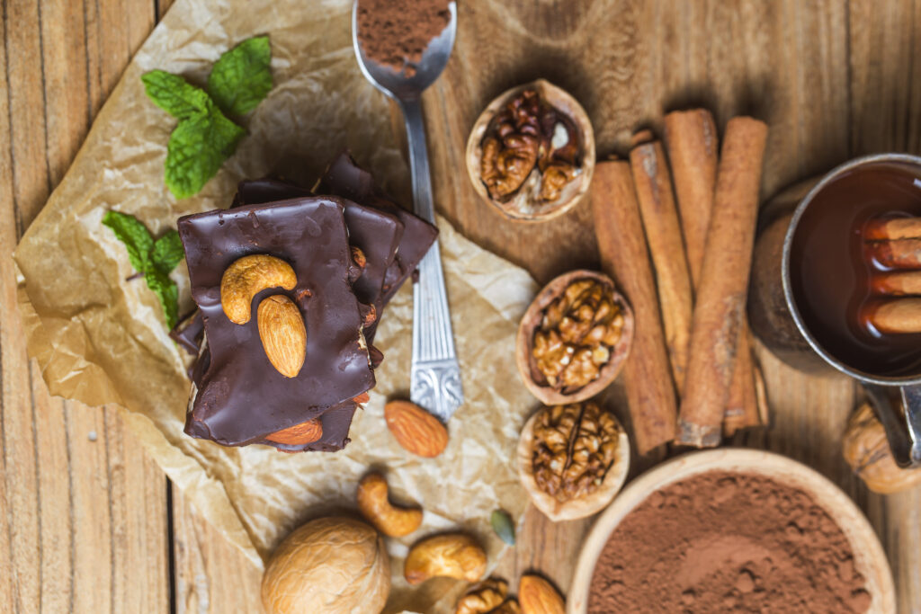 Assorted ingredients for making vegan fudge, including cocoa powder, vegan butter, and plant-based milk, laid out on a kitchen counter.