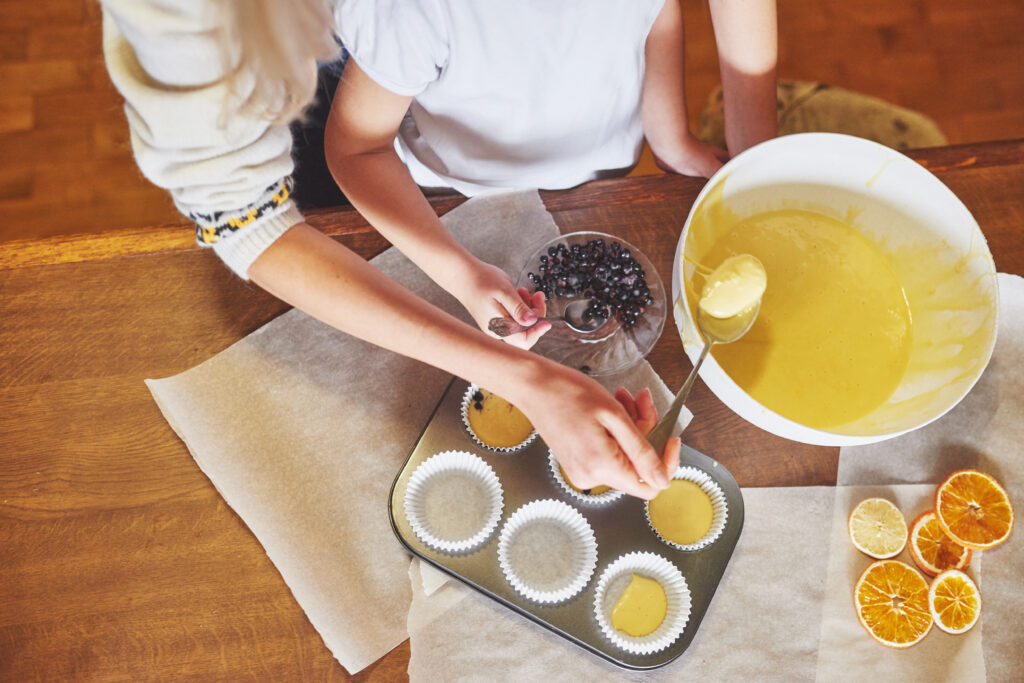 Preparing the pumpkin muffin batter, combining cake mix and pumpkin puree in a mixing bowl, for an easy two-ingredient recipe.