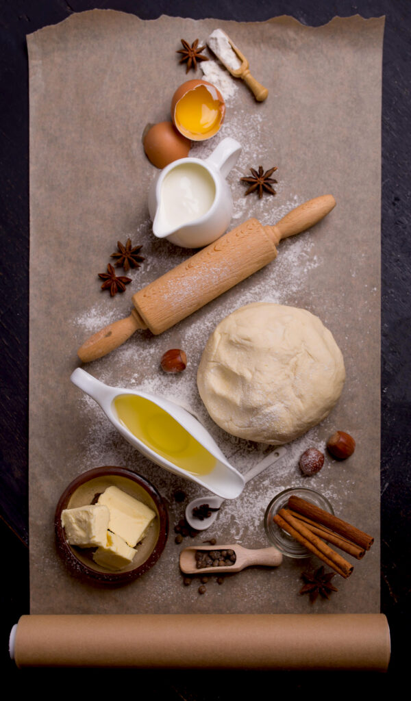 High-quality image showcasing key ingredients for cinnamon roll icing, including powdered sugar, butter, and vanilla extract neatly arranged on a kitchen table.