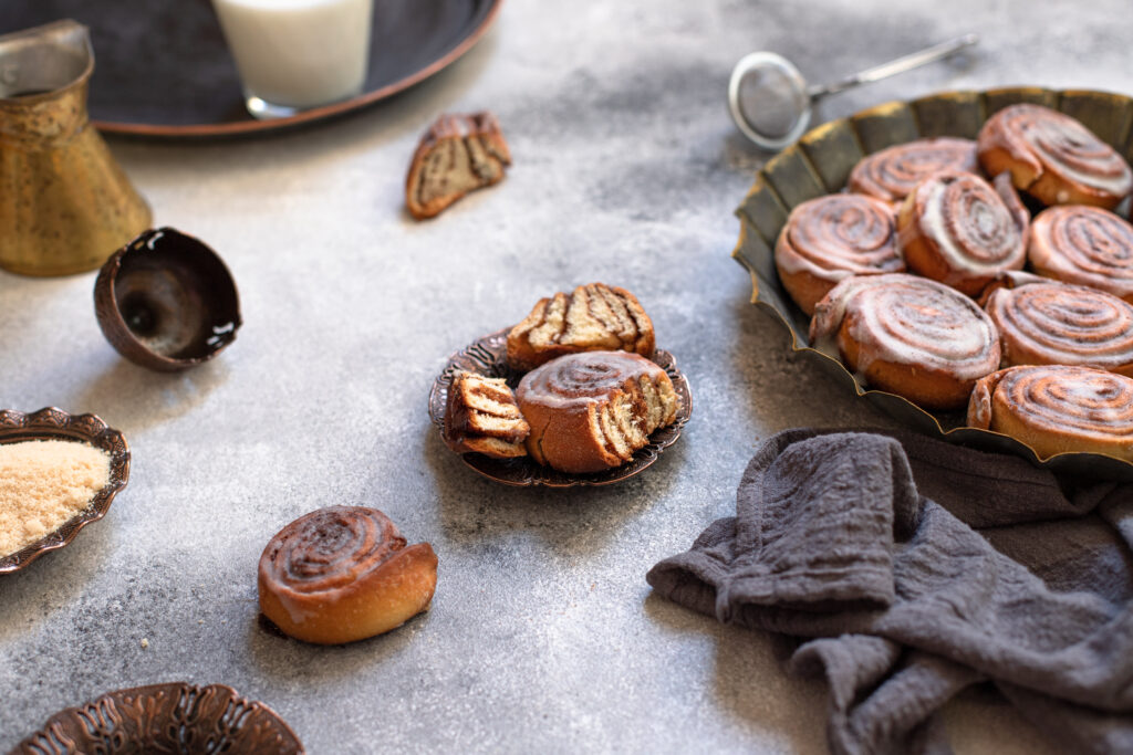 Display of healthier cinnamon bun frosting alternatives, including bowls of low-fat and sugar-free options.