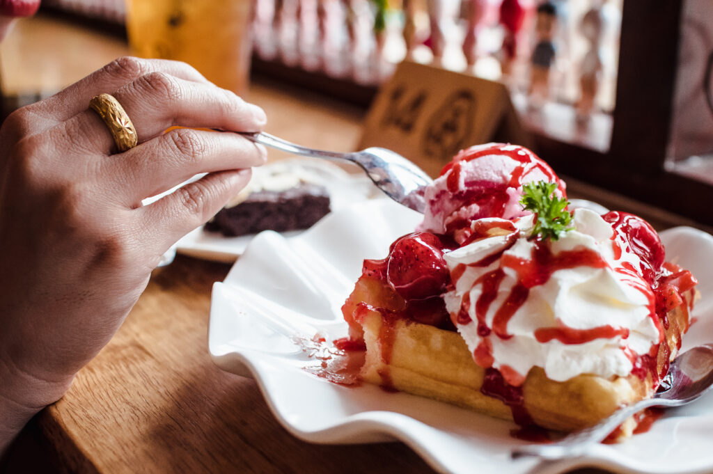 Homemade strawberry shortcake ice cream in a serving dish, garnished with fresh strawberries and crumbled cookies.